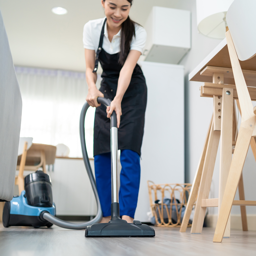 Woman cleaning a house with a hoover